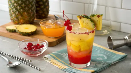 A Mai Tai mocktail being prepared with fresh ingredients and garnishes.